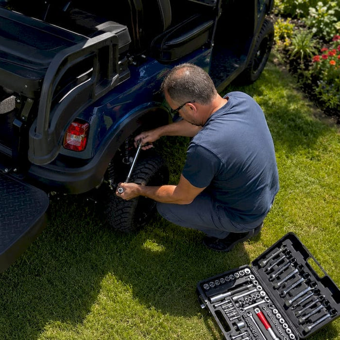 Man adjusting golf cart suspension outdoors