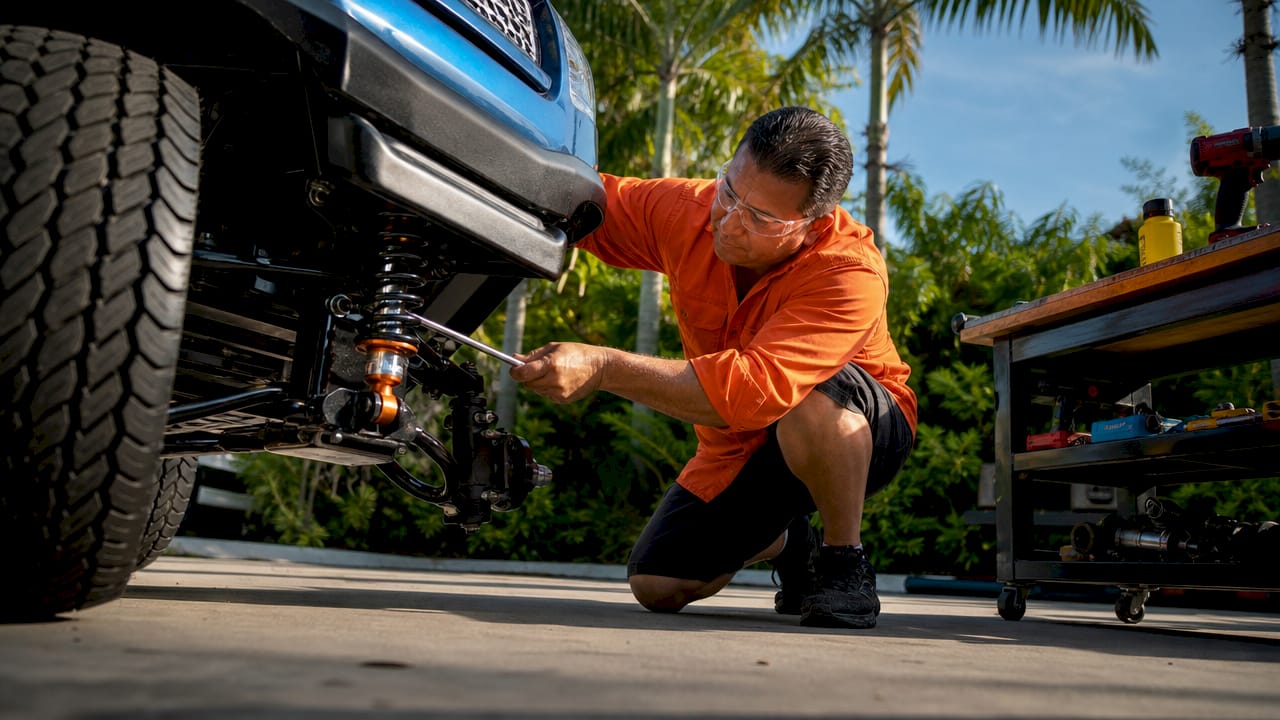 Mechanic inspecting golf cart suspension close-up
