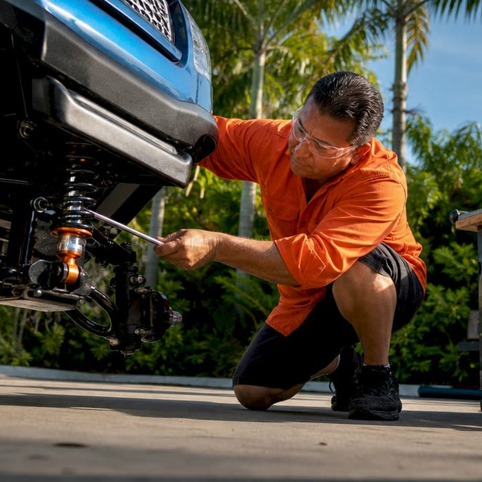Mechanic inspecting golf cart suspension close-up