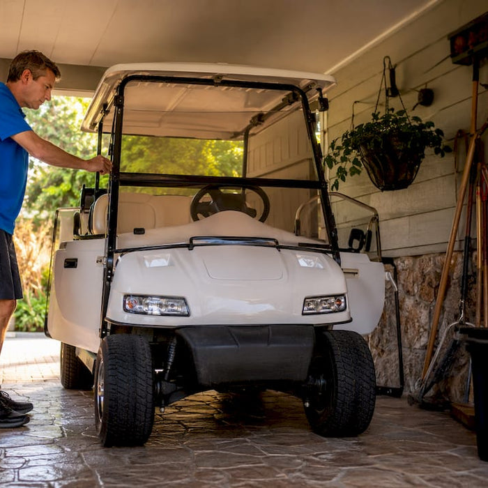 Technician storing golf cart in indoor garage