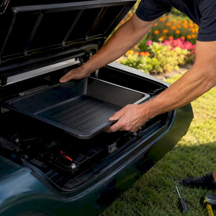 Hands installing underseat storage tray under golf cart seat
