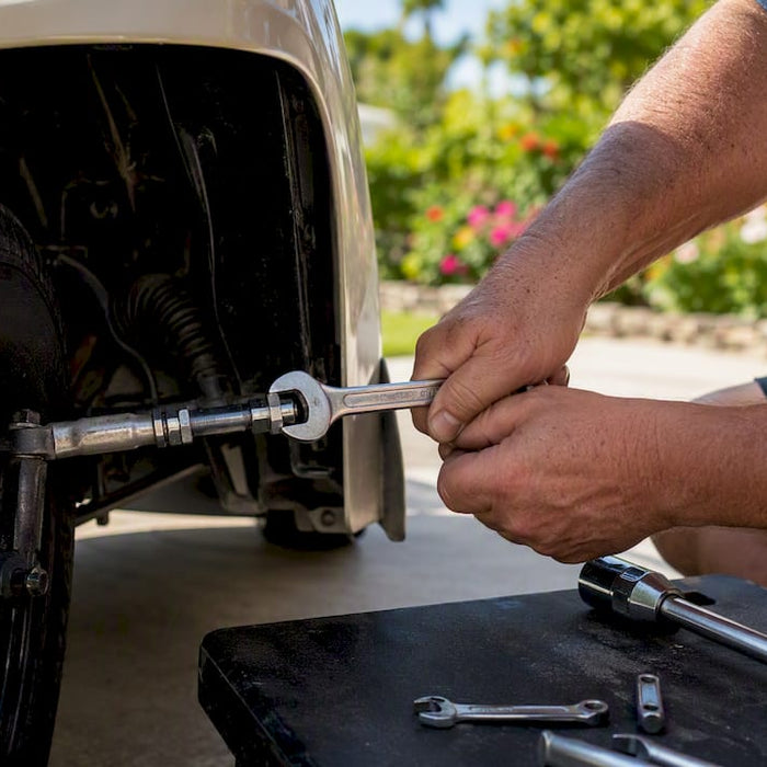 Hands adjusting golf cart tie-rod sleeve