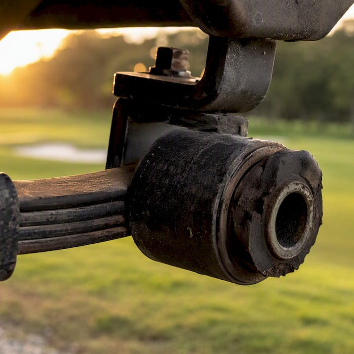 Close-up of worn leaf spring bushing on golf cart