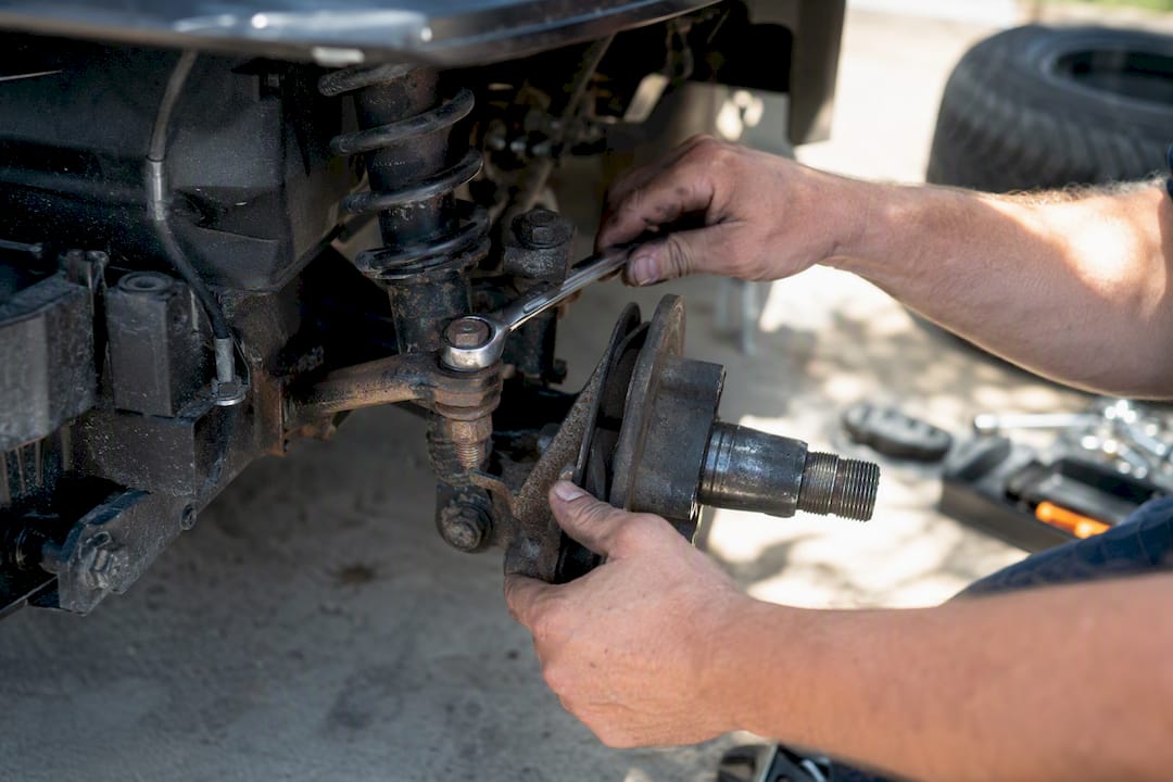 Hands adjusting golf cart suspension component