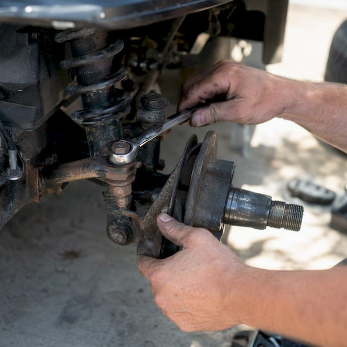 Hands adjusting golf cart suspension component