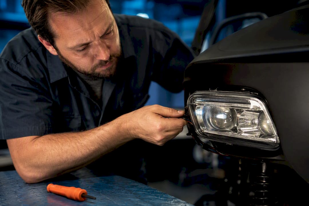 Technician inspecting golf cart headlight wiring