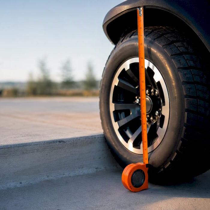 Partial golf cart tire measured beside curb